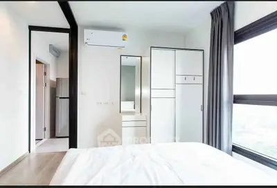 Bright modern bedroom with large window and sleek furniture