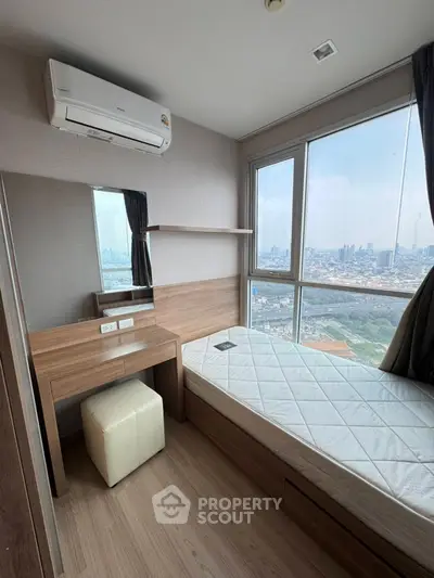 Cozy bedroom with city view, featuring a single bed and wooden furniture.