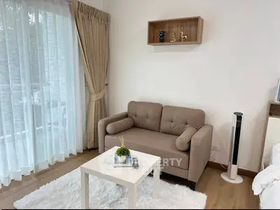 Cozy living room with beige sofa, white rug, and modern decor