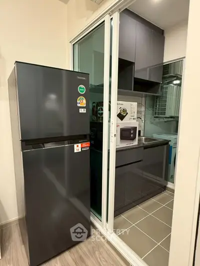 Modern kitchen with sleek black fridge and compact design