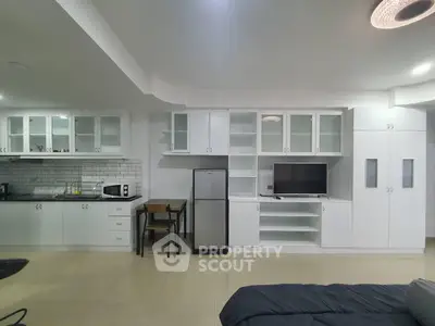 Modern open-plan kitchen and living area with sleek appliances and ample storage
