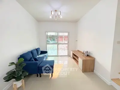 Bright living room with blue sofa and modern decor, perfect for relaxation.