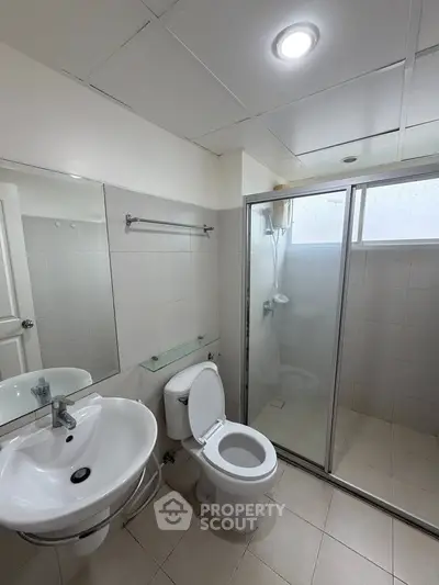 Modern bathroom with glass shower enclosure and sleek fixtures