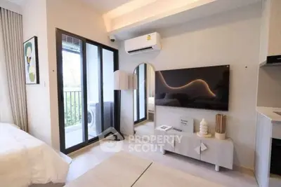 Modern living room with stylish decor, wall-mounted TV, and balcony access in a contemporary apartment.