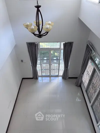 Spacious living room with high ceiling and large windows for natural light