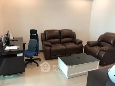 Cozy living room with leather sofas and modern office desk setup.