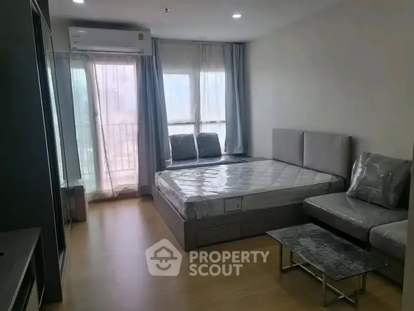 Modern bedroom with natural light and stylish furniture in a high-rise apartment.