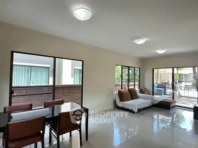 Spacious living room with modern dining area and large windows for natural light.