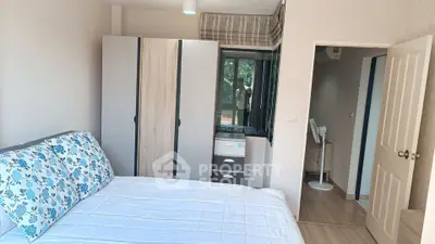 Cozy bedroom with modern wardrobe and natural light in a stylish apartment.