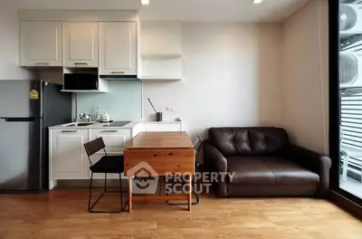 Modern compact kitchen with dining area and cozy sofa in a stylish apartment.