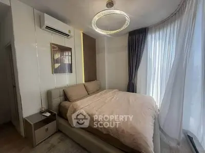 Luxurious bedroom with modern decor and large windows offering natural light.