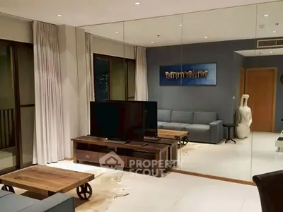 Modern living room with stylish furniture and large mirror wall, creating a spacious and elegant ambiance.