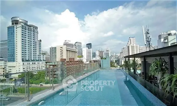 Stunning rooftop pool with panoramic city skyline views in a modern urban setting.