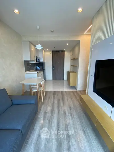 Modern living room with open kitchen layout and stylish furnishings in a contemporary apartment.