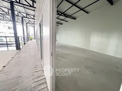 Spacious industrial-style unit with high ceilings and large windows, perfect for commercial use.