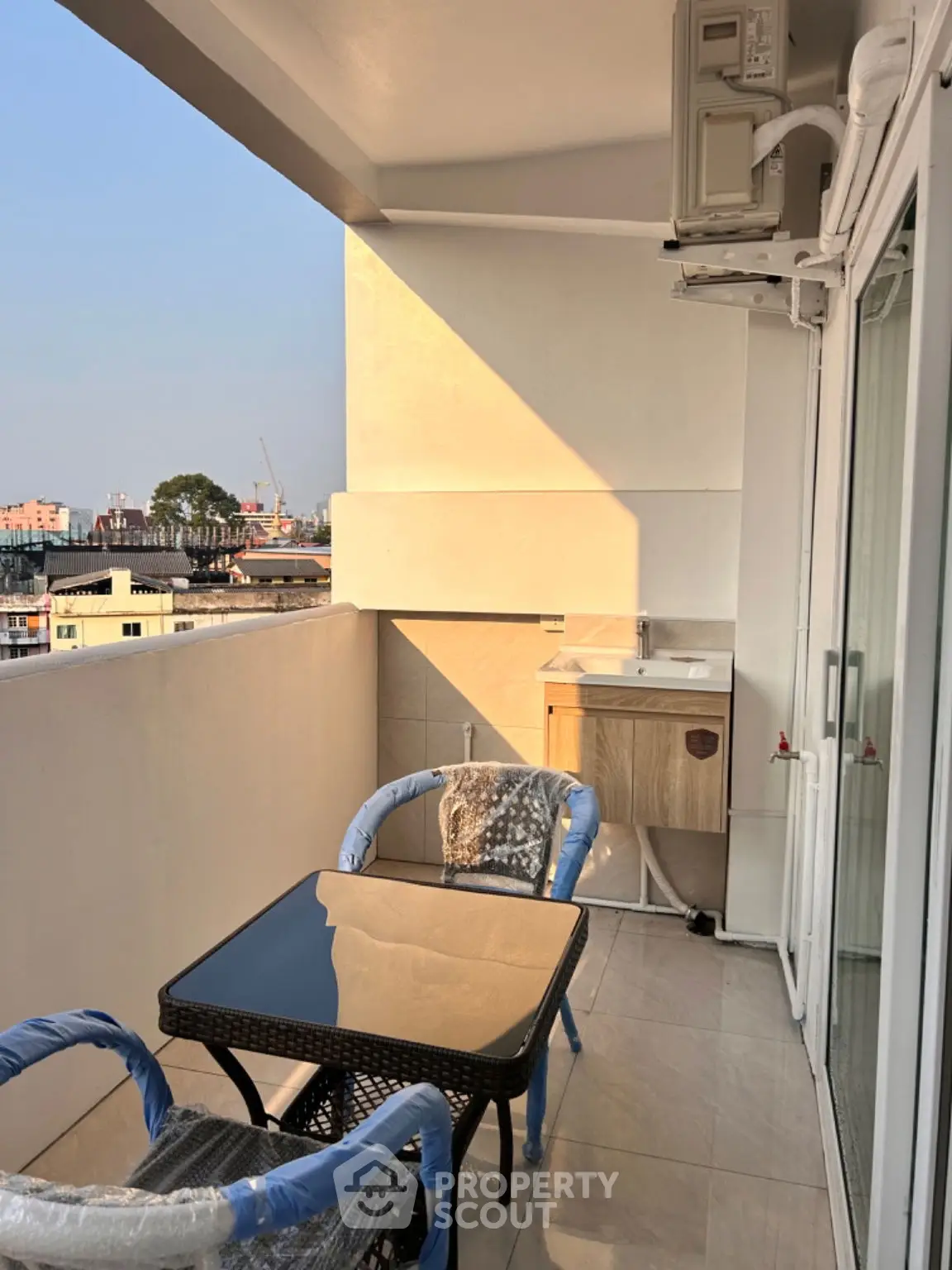Charming balcony with city view, cozy seating, and modern amenities for relaxing evenings.