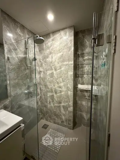 Modern bathroom with sleek glass shower and elegant marble tiles