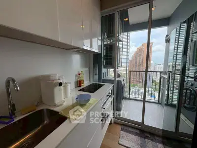 Modern kitchen with sleek white cabinets and stunning city view from balcony.