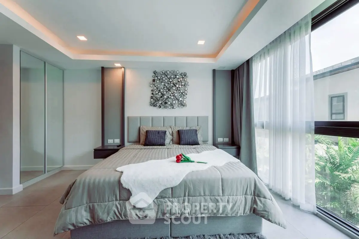 Luxurious bedroom with modern decor and large windows offering natural light