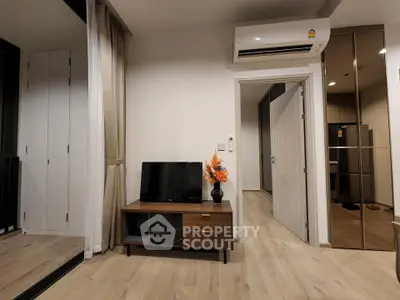 Modern living room with sleek TV stand and air conditioning, featuring elegant decor and wooden flooring.