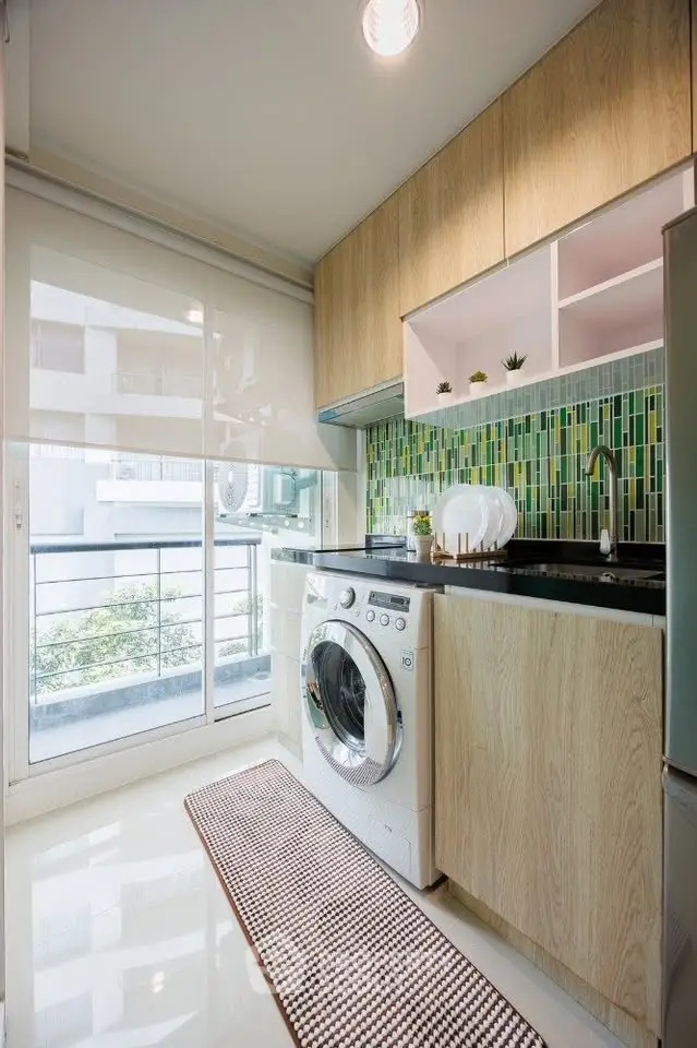 Modern kitchen with washing machine and stylish backsplash in a bright apartment.