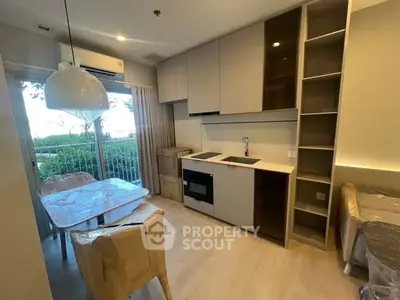 Modern kitchen with dining area and balcony view in stylish apartment