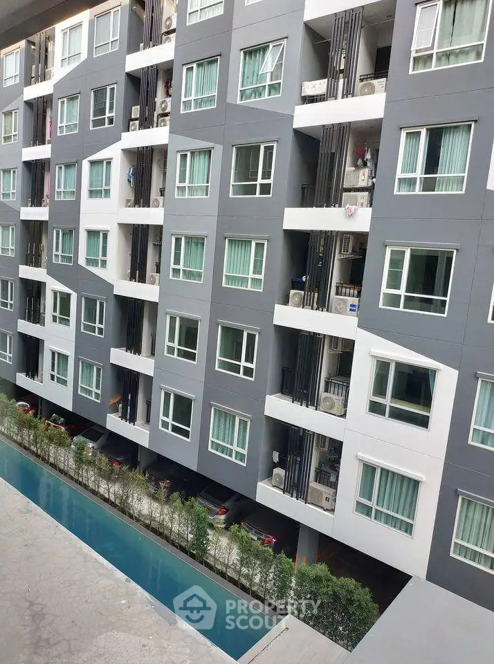 Modern apartment building with pool view and lush greenery