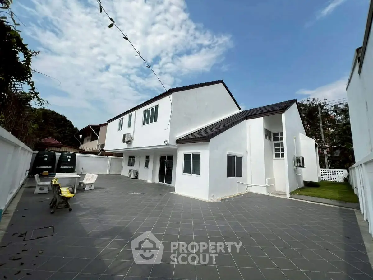 Spacious white modern house with tiled courtyard and clear blue sky