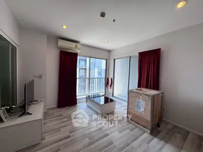 Spacious living room with modern decor and large windows in a high-rise apartment.