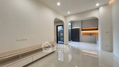 Modern open layout living room with sleek kitchen and glossy floors