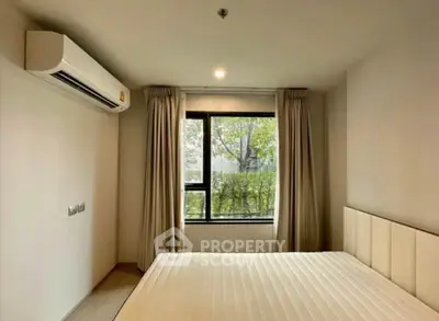 Modern bedroom with large window and air conditioning unit, offering a serene and comfortable living space.