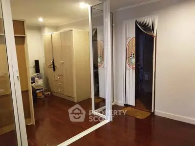 Spacious bedroom with wooden flooring and mirrored closet doors