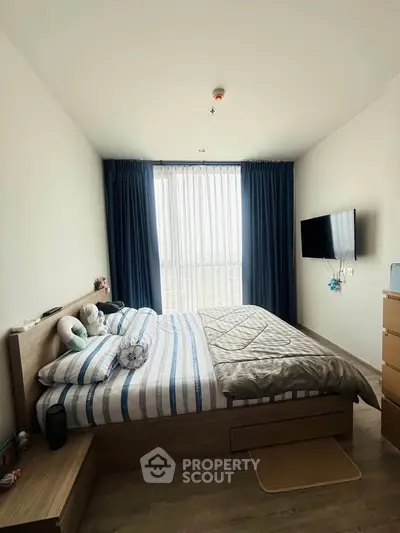 Cozy bedroom with modern decor and large window for natural light