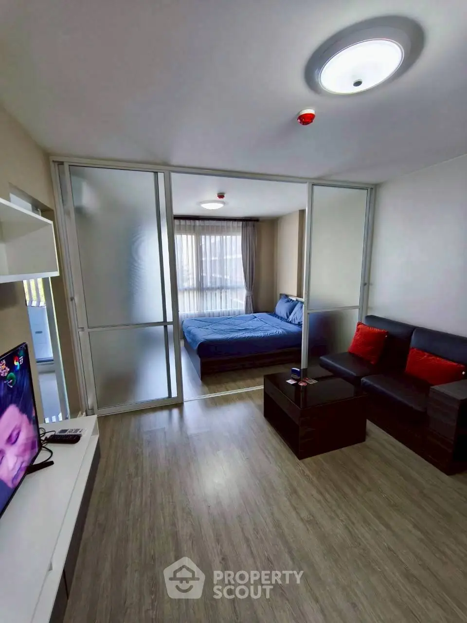 Modern studio apartment with sliding glass doors and cozy furnishings.