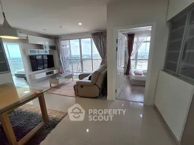 Spacious modern living room with balcony and city view, featuring elegant decor and ample natural light.