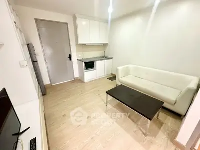 Modern compact living room with kitchenette and sleek furnishings