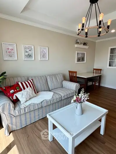 Charming living room with cozy striped sofa and elegant chandelier
