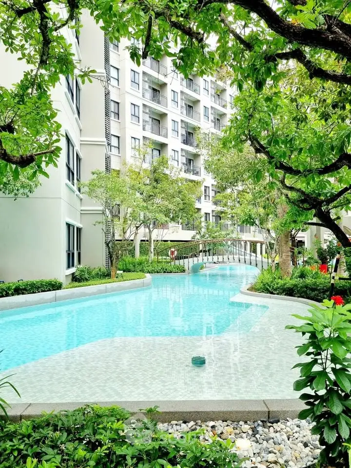 Luxurious apartment complex with stunning pool and lush greenery, perfect for relaxation and leisure.