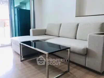 Modern living room with sleek sofa and glass coffee table in a stylish apartment.