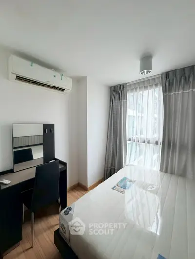 Bright and cozy bedroom with modern furnishings and large window for natural light.