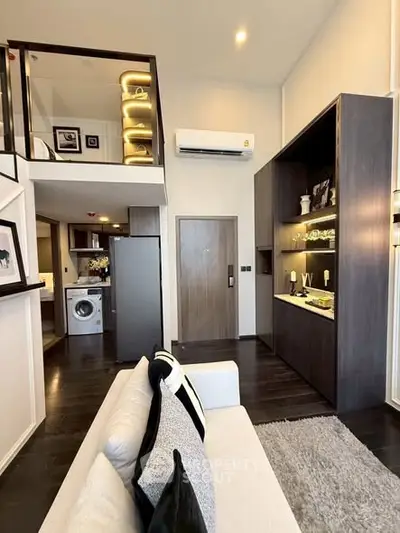 Modern duplex apartment with stylish interior, featuring a cozy living area and a compact laundry space.