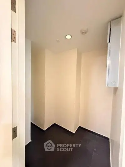 Compact storage room with sleek black flooring and minimalist design.