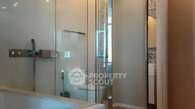 Modern bathroom with glass shower and sleek fixtures.