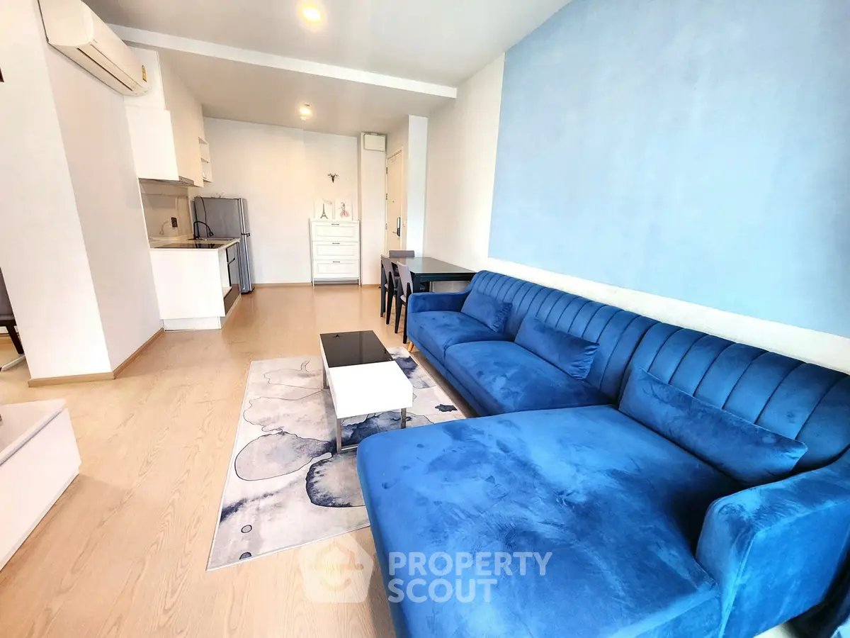 Modern living room with blue sofa and open kitchen layout