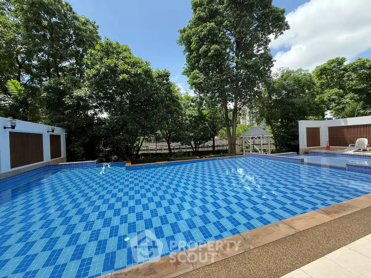 Stunning outdoor pool surrounded by lush greenery, perfect for relaxation and leisure.