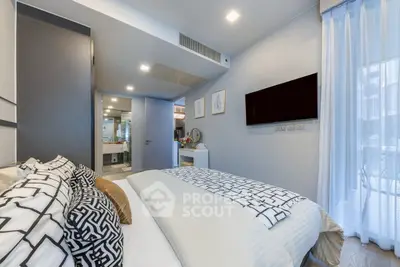 Modern bedroom with stylish decor and wall-mounted TV in a cozy apartment.