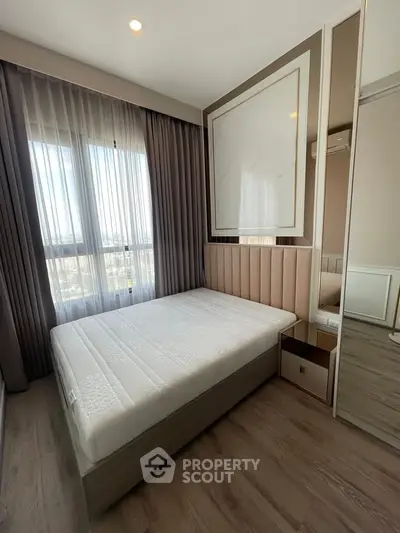 Modern bedroom with large window and stylish decor in a contemporary apartment.