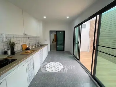Modern kitchen with sleek design and ample natural light, featuring open layout and stylish decor.