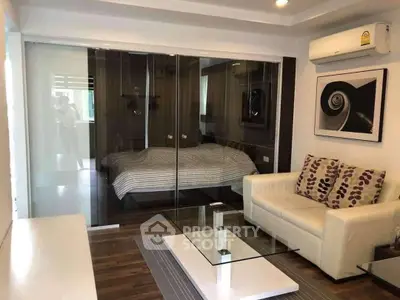 Modern living room with glass partition, stylish sofa, and air conditioning unit.