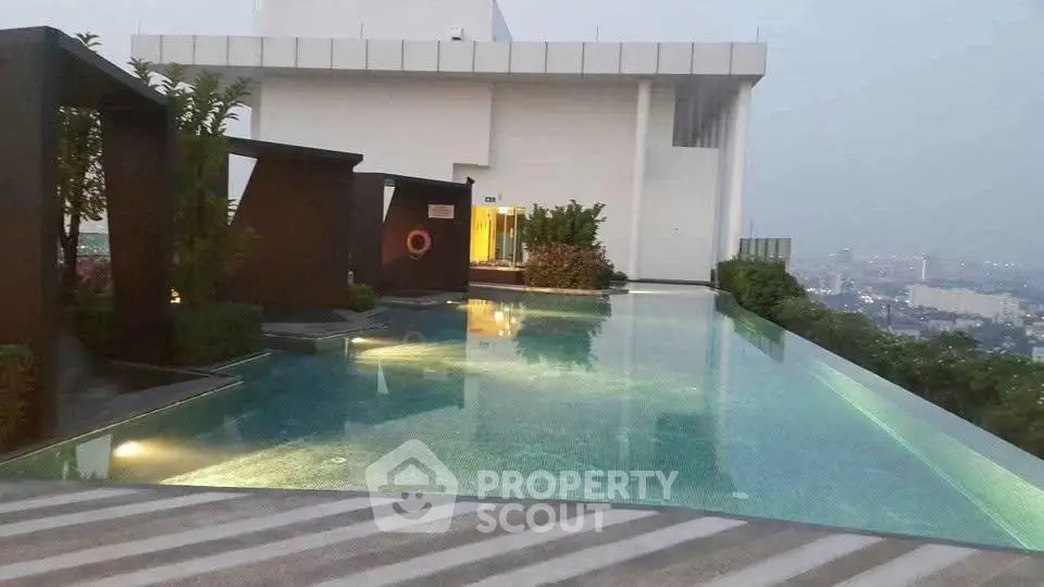 Luxurious rooftop infinity pool with stunning city views at dusk, perfect for relaxation and leisure.
